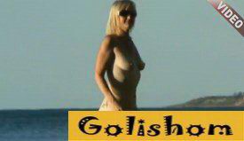 A beautiful nudist is walking on the beach